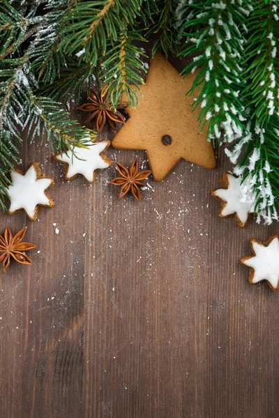 Wooden background with fir branches and cookies, top view — Stock Photo, Image