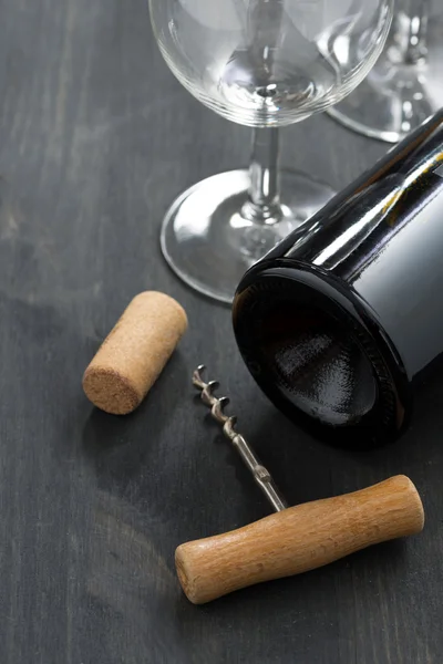 Fles rode wijn, bril en kurkentrekker op houten achtergrond — Stockfoto