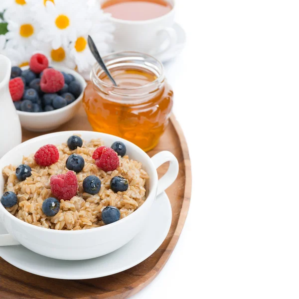 Oat porridge with berries and honey, black tea, isolated — Stock Photo, Image