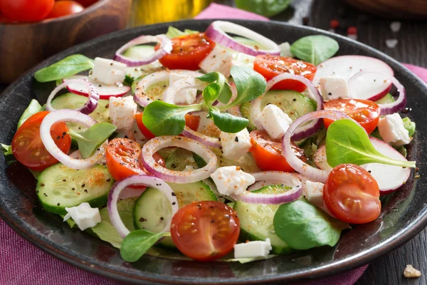Свежий овощной салат с сыром фета на тарелке, крупным планом — стоковое фото