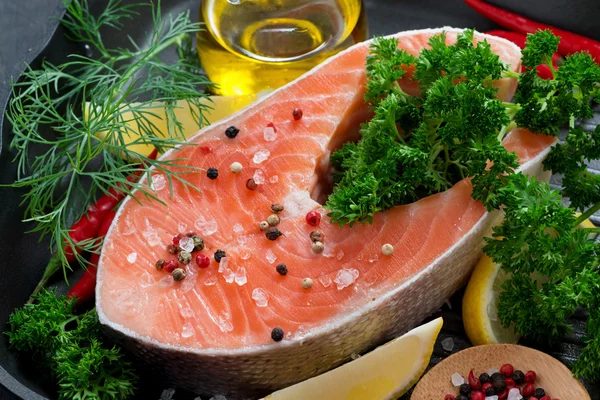 Свежий лосось стейк и ингредиенты для приготовления пищи на сковороде — стоковое фото