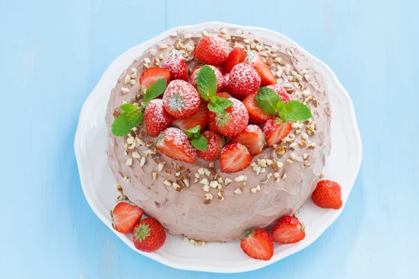 Chocolate cake with fresh strawberries on a blue background — Stock Photo, Image