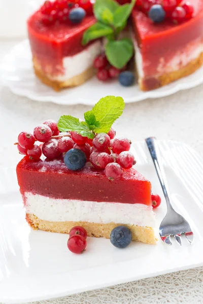 Piece of cheesecake with berry jelly on a white plate — Stock Photo, Image