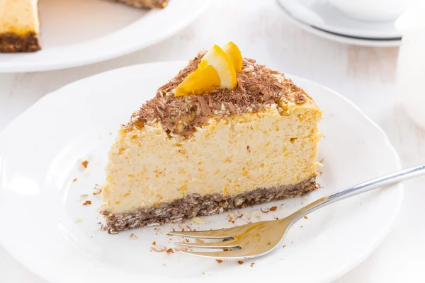 Piece of orange cheesecake with chocolate on a plate, top view — Stock Photo, Image