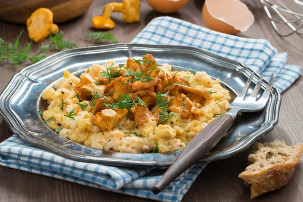 Ovos mexidos com chanterelles e ervas em uma chapa — Fotografia de Stock