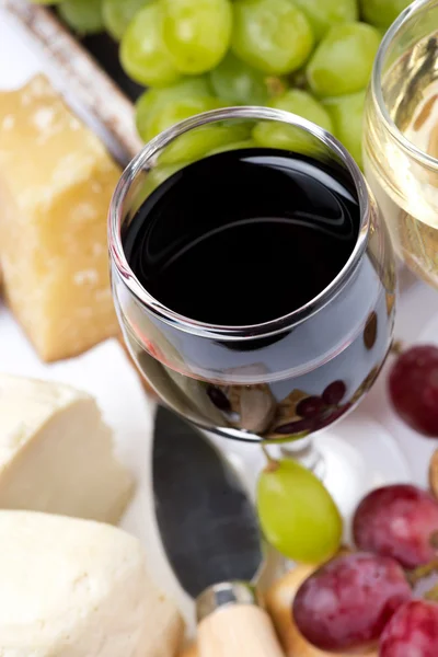 Closeup of glass of red wine, grapes and cheese, top view — Stock Photo, Image