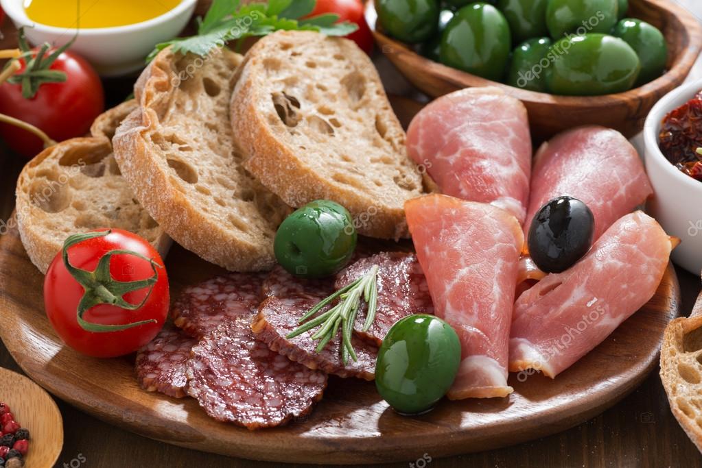 assorted Italian antipasti deli meats, olives and bread — Stock Photo
