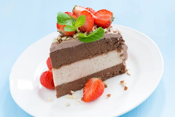 Pedazo de pastel de chocolate de tres capas en el plato —  Fotos de Stock