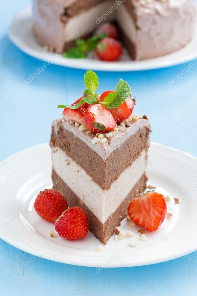 Piece of chocolate cake of three layers with fresh strawberries