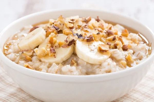 Harina de avena con plátano, miel y nueces en tazón, primer plano — Foto de Stock