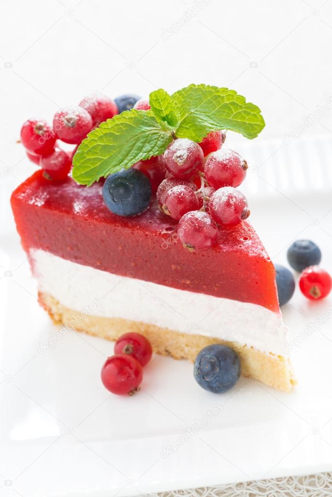 Piece of delicious cheesecake with berry jelly on a white plate