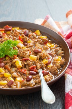Meksika yemeği chili con carne bir kahverengi seramik plaka, dikey