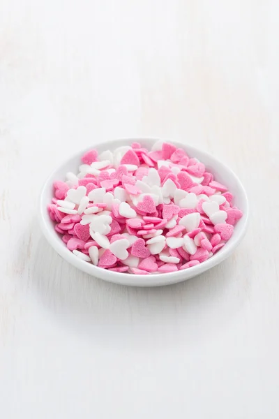 Colored sugar hearts in a white bowl, vertical — Stock Photo, Image