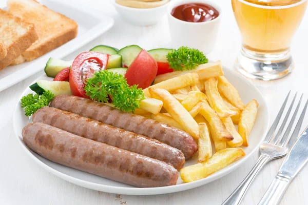 Grilled sausages with French fries and vegetables — Stock Photo, Image