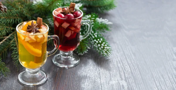 Würzige Weihnachtsgetränke in Gläsern auf Holzgrund — Stockfoto