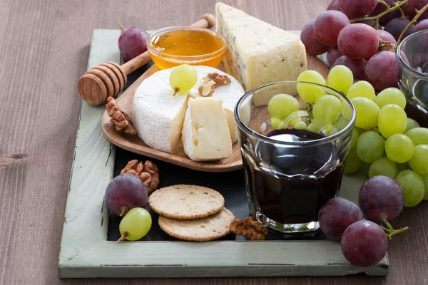 Verschiedene Vorspeisen zu Wein - Käse, frische Trauben, Cracker — Stockfoto