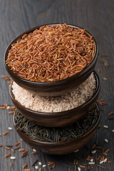 Arroz rojo, silvestre y rosa en un tazón de cerámica, vista superior — Foto de Stock