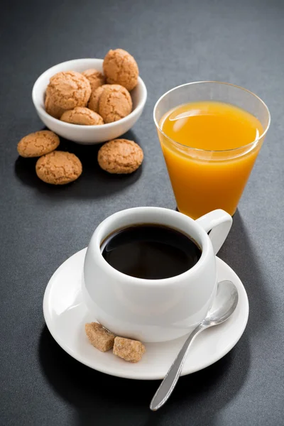 Kawa, włoskie ciasteczka i sok pomarańczowy na czarnym tle — Zdjęcie stockowe
