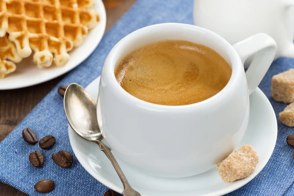 Cup of coffee, waffles and a jug of milk, close-up — Stock Photo, Image