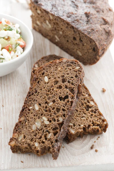 Rye bread with seeds on board — Stock Photo, Image