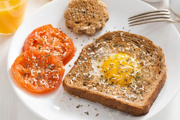 Ovo frito em uma torrada e tomates grelhados para o café da manhã — Fotografia de Stock