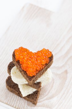 ahşap masa, üstten görünüm üzerinde kalp şeklinde kırmızı havyar ile tost