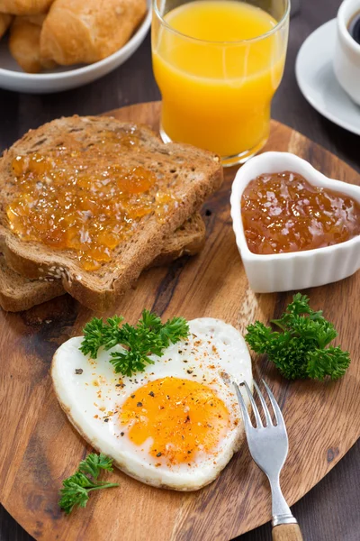 Fried eggs in the form of heart on wooden board, top view — Stock Photo, Image
