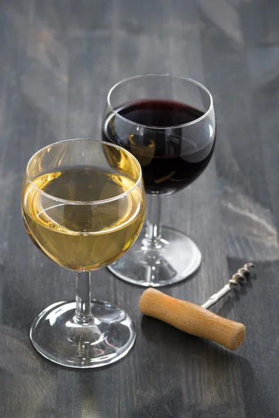 Glas Weiß- und Rotwein auf dunklem Holzgrund — Stockfoto