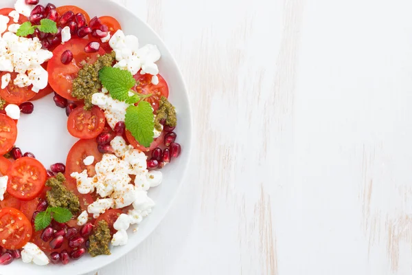 Salada com queijo cottage, tomate, pesto de hortelã e romã — Fotografia de Stock