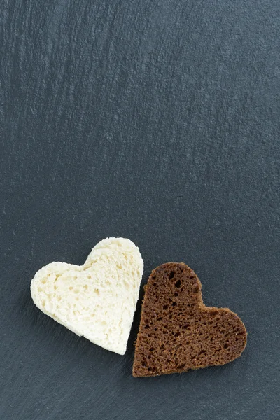 Toasted rye and white bread in the form of heart on dark — Stock Photo, Image