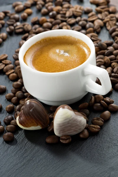 Kopp espresso, kaffebönor bakgrund och choklad godis — Stockfoto