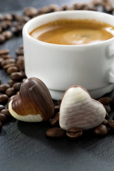 Espresso, kaffebönor och choklad godis i ett hjärta form — Stockfoto