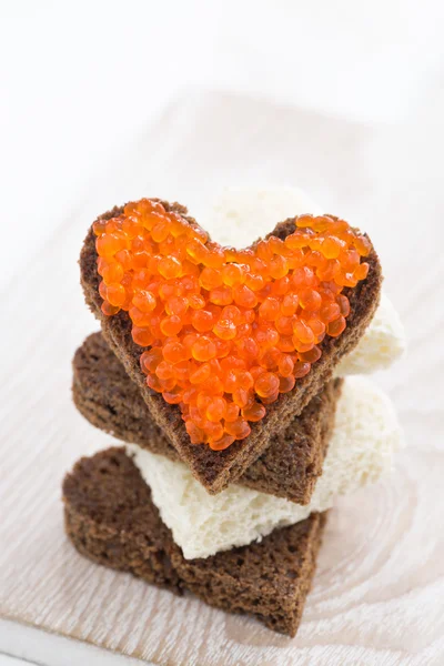 Toast with red caviar in heart shape, close-up, vertical — Stock Photo, Image