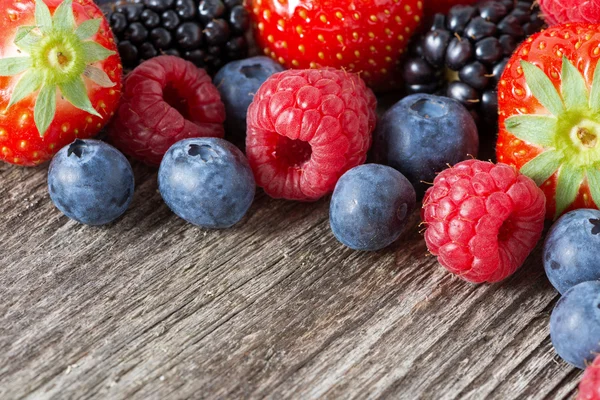 Assorted fresh juicy berries on wooden background, horizontal — Stock Photo, Image