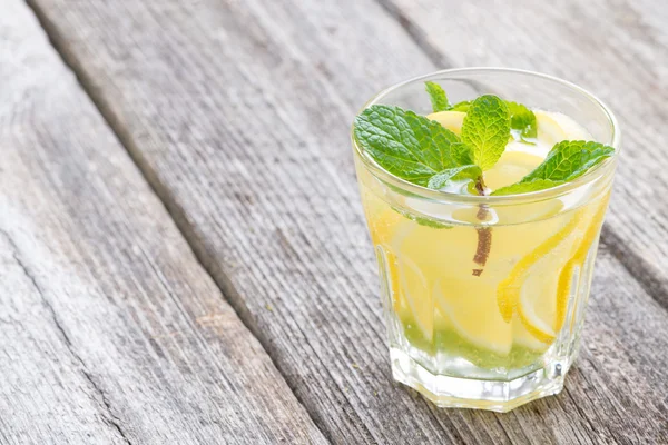 Освежающий мятный лимонад в стекле на деревянном фоне — стоковое фото