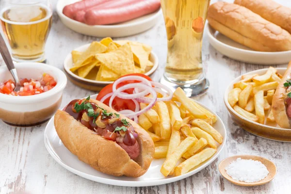 Perritos calientes con papas fritas, cerveza y bocadillos —  Fotos de Stock