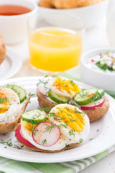 Buns with egg and vegetables on plate for breakfast, vertical — Stock Photo, Image