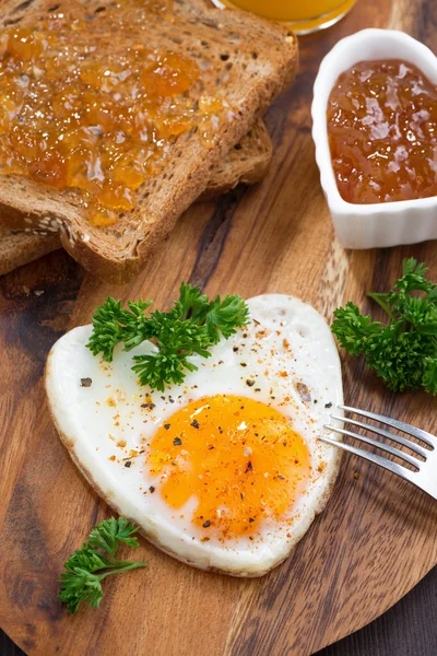 Ahşap masa, dikey üzerinde kalp şeklinde kızarmış yumurta — Stok fotoğraf