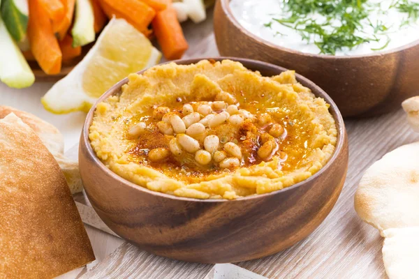 Hummus in wooden bowl with pita bread and fresh vegetables — Stock Photo, Image