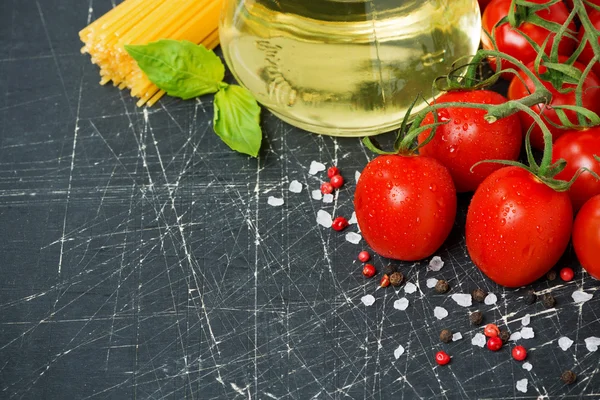 Dark background with cherry tomatoes, pasta, fresh basil — Stock Photo, Image