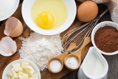 Ahşap bir tahtanın üzerinde yemek malzemeleri, üst manzara.
