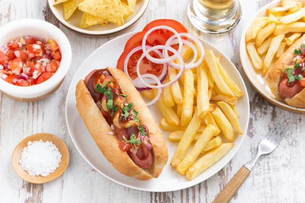 Fast food - hot dog with French fries and chips on wooden table — Stock Photo, Image