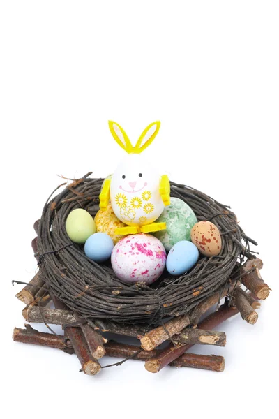 Nido con huevos de Pascua de colores y conejo, aislado — Foto de Stock