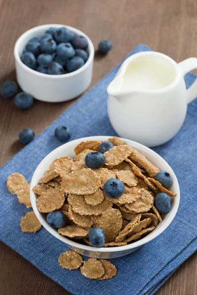 Wholegrain flakes with blueberries and milk, vertical, top view — Stock Photo, Image