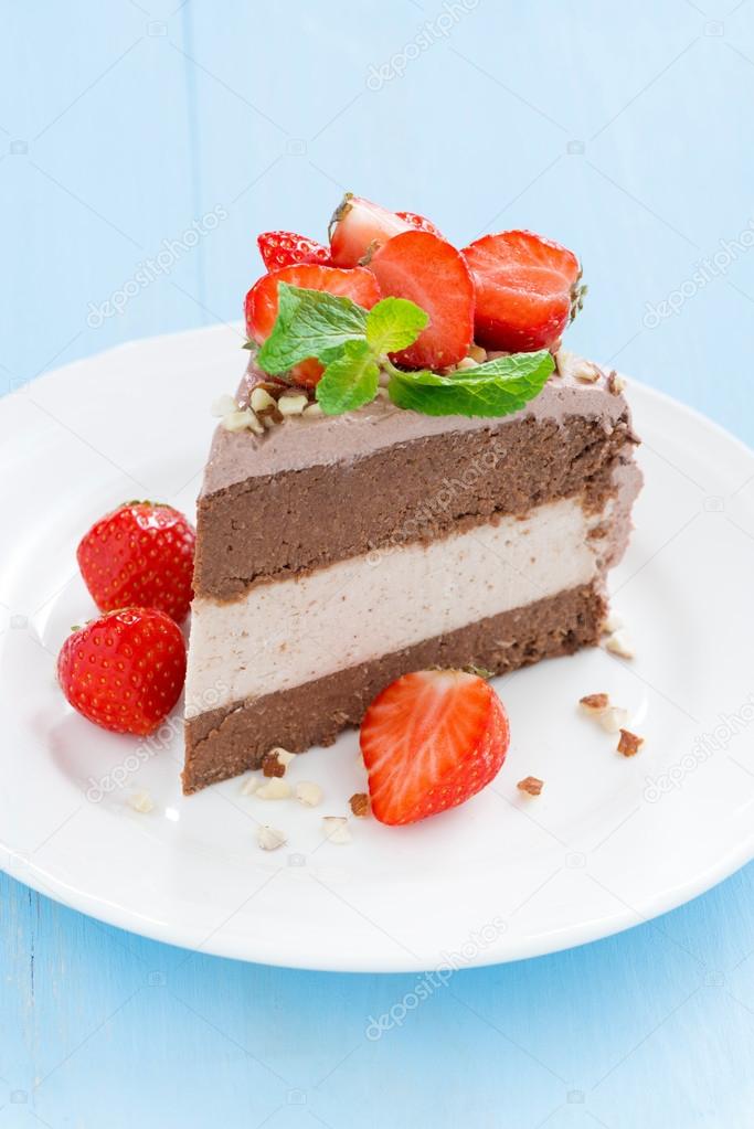 piece of chocolate cake of three layers with fresh strawberries 