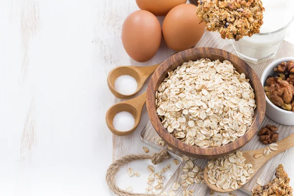 Copos de avena e ingredientes en una mesa de madera blanca, horizontal , —  Fotos de Stock