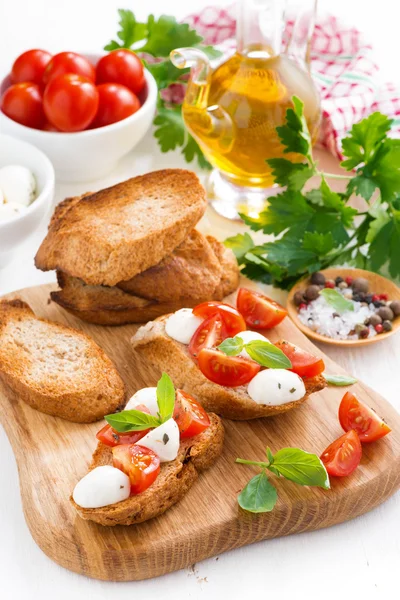 Toasts with mozzarella, basil and cherry tomatoes — Stock Photo, Image