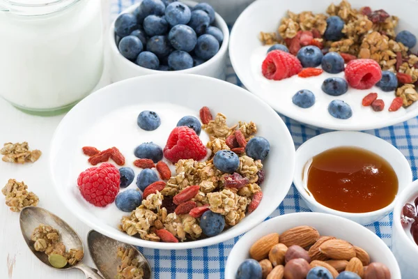 Desayuno con granola, bayas, miel y yogur en una pestaña blanca — Foto de Stock