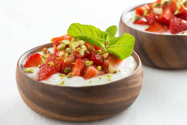 Efterrätt yoghurt med färska jordgubbar, pistaschmandlar och mynta — Stockfoto