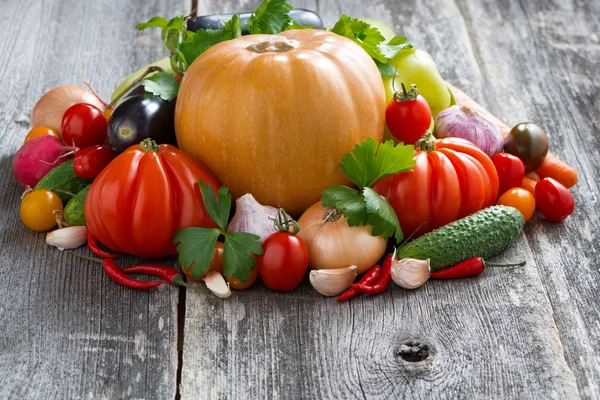 Cosecha de verduras frescas de temporada sobre un fondo de madera — Foto de Stock